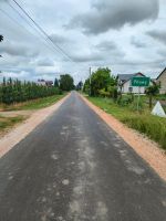 Droga w miejscowości Pilawy. Na zdjęciu widoczny znak z nazwą miejscowości w oddali budynki mieszkalne oraz drzewa.